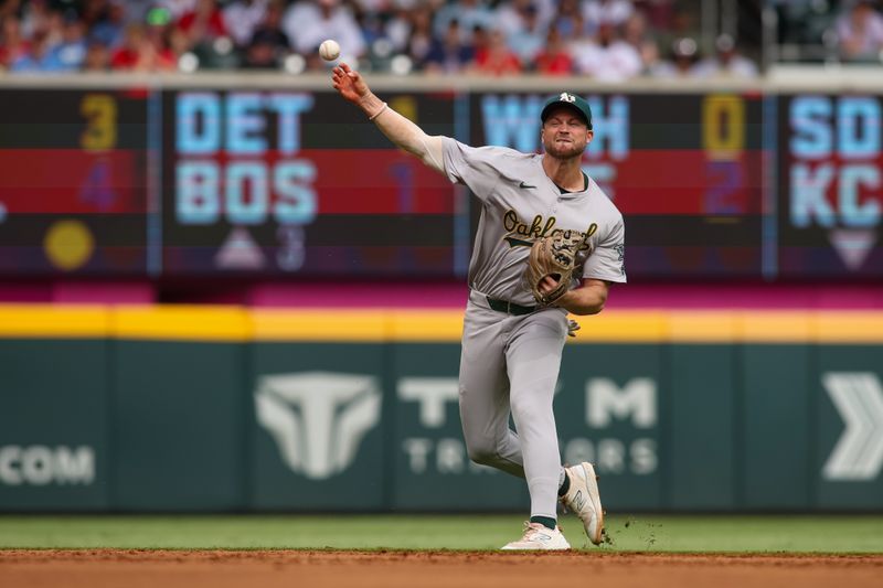 Jun 1, 2024; Atlanta, Georgia, USA; Oakland Athletics shortstop Max Schuemann (12) throws a runner out at first against the Atlanta Braves in the second inning at Truist Park. Mandatory Credit: Brett Davis-USA TODAY Sports