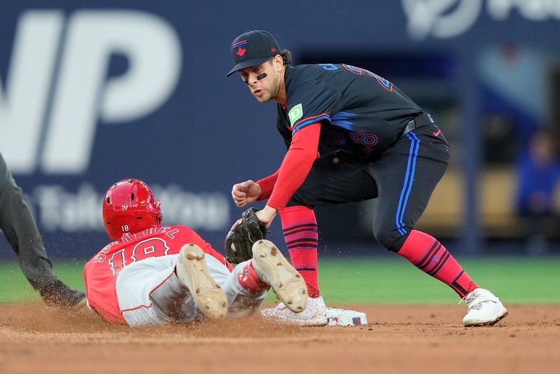 Aug 23, 2024; Toronto, Ontario, CAN; Toronto Blue Jays shortstop Ernie Clement (28) tags Los Angeles Angels first baseman Nolan Schanuel (18) out at second base during the third inning at Rogers Centre. Mandatory Credit: John E. Sokolowski-USA TODAY Sports