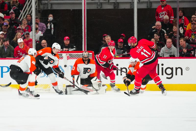 Mar 21, 2024; Raleigh, North Carolina, USA; Philadelphia Flyers goaltender Samuel Ersson (33) stops the shot attempt by Carolina Hurricanes center Jordan Staal (11) during the second period at PNC Arena. Mandatory Credit: James Guillory-USA TODAY Sports