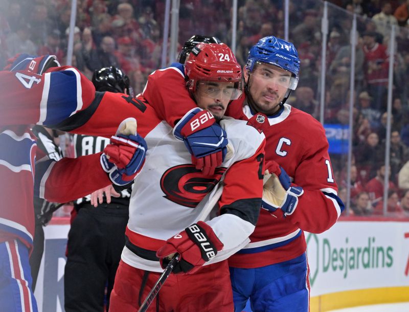 Mar 24, 2026; Montreal, Quebec, CAN; Montreal Canadiens forward Nick Suzuki (14) stops Carolina Hurricanes forward Seth Jarvis (24) from grabbing Montreal Canadiens defenseman Lane Hutson (48) during the second period at the Bell Centre. Mandatory Credit: Eric Bolte-Imagn Images