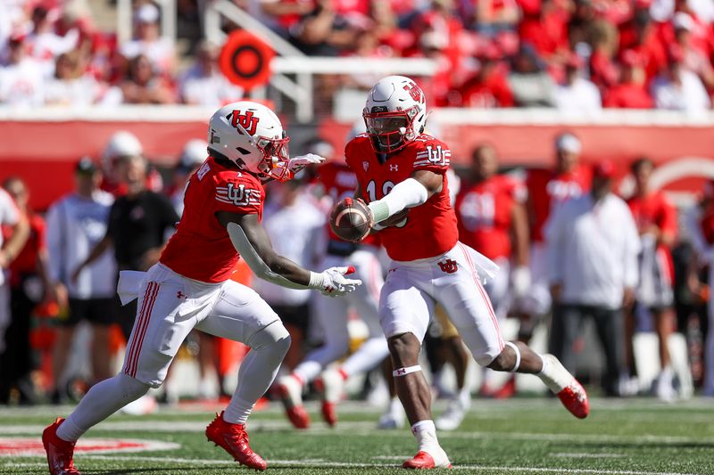 Sep 23, 2023; Salt Lake City, Utah, USA; Utah Utes quarterback Nate Johnson (13) hands the ball off to running back Jaylon Glover (1) against the UCLA Bruins in the second quarter at Rice-Eccles Stadium. Mandatory Credit: Rob Gray-USA TODAY Sports