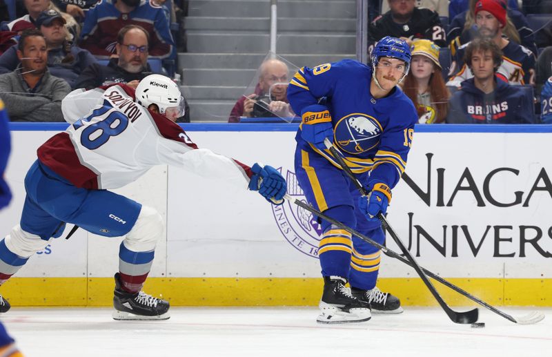 Oct 13, 2025; Buffalo, New York, USA;  Colorado Avalanche defenseman Ilya Solovyov (28) tries to block a pass by Buffalo Sabres center Peyton Krebs (19) during the second period at KeyBank Center. Mandatory Credit: Timothy T. Ludwig-Imagn Images