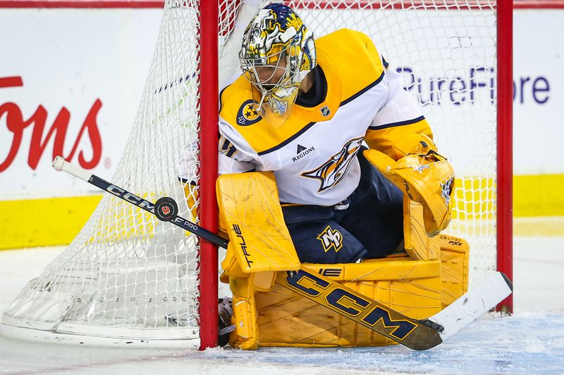 Nov 15, 2024; Calgary, Alberta, CAN; Nashville Predators goaltender Juuse Saros (74) makes a save against the Calgary Flames during the second period at Scotiabank Saddledome. Mandatory Credit: Sergei Belski-Imagn Images