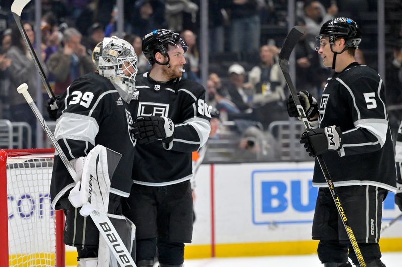 Apr 11, 2024; Los Angeles, California, USA; Los Angeles Kings center Pierre-Luc Dubois (80) and defenseman Andreas Englund (5) congratulate goaltender Cam Talbot (39) after defeating the Calgary Flames at Crypto.com Arena. Mandatory Credit: Jayne Kamin-Oncea-USA TODAY Sports