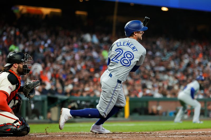 Jul 10, 2024; San Francisco, California, USA; Toronto Blue Jays third baseman Ernie Clement (28) hits a RBI single during the sixth inning against the San Francisco Giants at Oracle Park. Mandatory Credit: Sergio Estrada-USA TODAY Sports