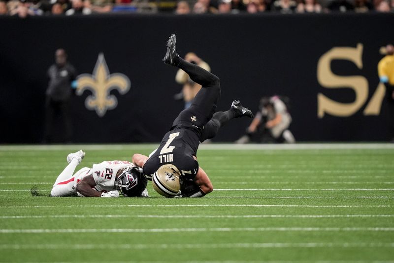 Atlanta Falcons cornerback Clark Phillips III (22) upends New Orleans Saints tight end Taysom Hill (7) during the first half of an NFL football game, Sunday, Nov. 10, 2024, in New Orleans. (AP Photo/Gerald Herbert)