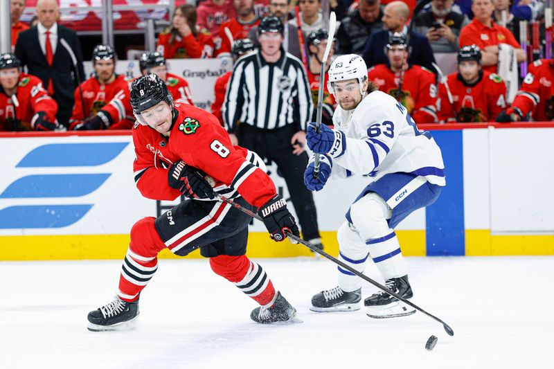 Nov 15, 2025; Chicago, Illinois, USA; Chicago Blackhawks center Ryan Donato (8) battles for the puck with Toronto Maple Leafs left wing Matias MacCelli (63) during the first period at United Center. Mandatory Credit: Kamil Krzaczynski-Imagn Images