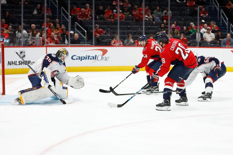 Sep 27, 2024; Washington, District of Columbia, USA; Washington Capitals forward Andrew Cristell (28) and Capitals center Connor McMichael (24) skate in on Columbus Blue Jackets goaltender Pavel Cajan (30) as Blue Jackets defenseman Samuel Knazko (62) defends in the third period at Capital One Arena. Mandatory Credit: Geoff Burke-Imagn Images