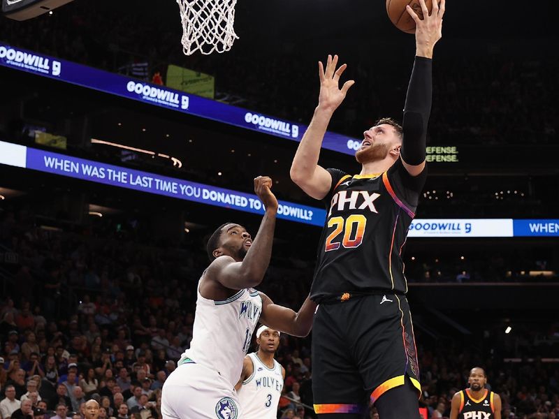 PHOENIX, ARIZONA - NOVEMBER 15: Jusuf Nurkic #20 of the Phoenix Suns attempts a shot over Shake Milton #18 of the Minnesota Timberwolves during the second half of the NBA game at Footprint Center on November 15, 2023 in Phoenix, Arizona. The Suns defeated the Timberwolves 133-115. NOTE TO USER: User expressly acknowledges and agrees that, by downloading and or using this photograph, User is consenting to the terms and conditions of the Getty Images License Agreement.  (Photo by Christian Petersen/Getty Images)