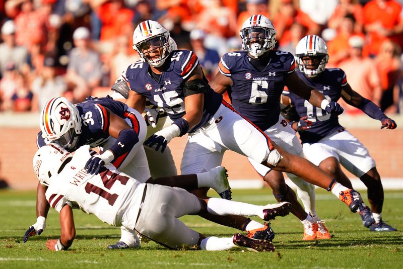 Oct 28, 2023; Auburn, Alabama, USA; Auburn Tigers linebacker Jalen McLeod (35) tackles Mississippi State Bulldogs quarterback Mike Wright (14) for a sack as he slips for a loss during the second quarter at Jordan-Hare Stadium. Mandatory Credit: John David Mercer-USA TODAY Sports