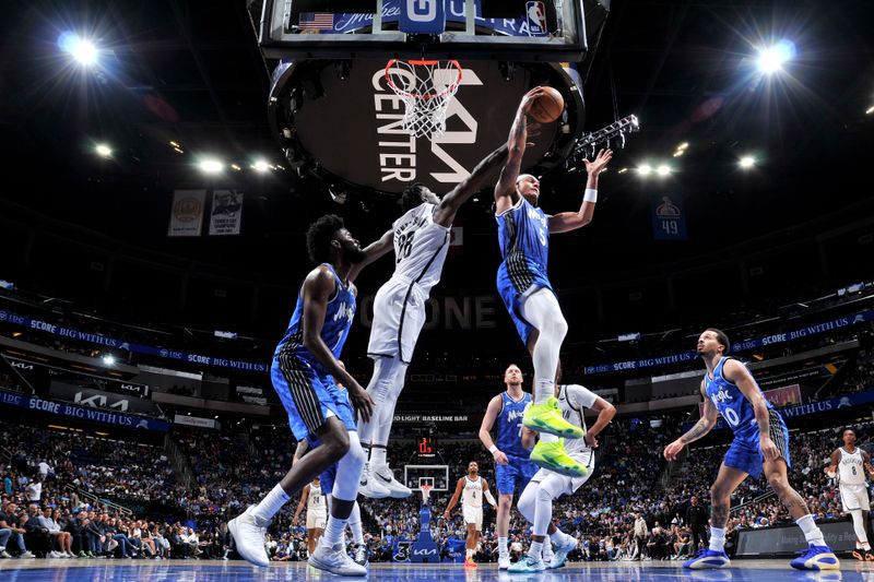 ORLANDO, FL - MARCH 13: Paolo Banchero #5 of the Orlando Magic rebounds the ball during the game against the Brooklyn Nets on March 13, 2024 at the Kia Center in Orlando, Florida. NOTE TO USER: User expressly acknowledges and agrees that, by downloading and or using this photograph, User is consenting to the terms and conditions of the Getty Images License Agreement. Mandatory Copyright Notice: Copyright 2024 NBAE (Photo by Fernando Medina/NBAE via Getty Images)