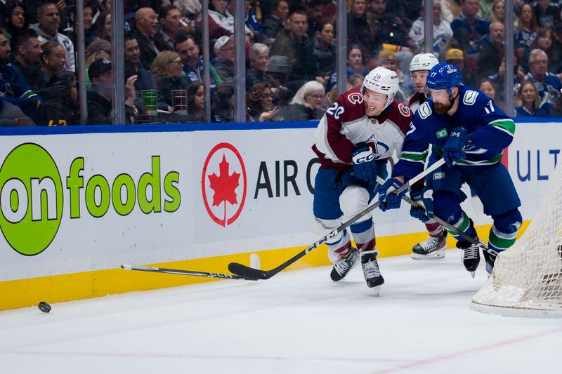 Mar 13, 2024; Vancouver, British Columbia, CAN; Colorado Avalanche forward Ross Colton (20) battles with Vancouver Canucks defenseman Filip Hronek (17) in the second period at Rogers Arena. Mandatory Credit: Bob Frid-USA TODAY Sports