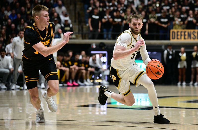 Jan 14, 2026; West Lafayette, Indiana, USA; Purdue Boilermakers guard Braden Smith (3) drives past Iowa Hawkeyes guard Bennett Stirtz (14) during the second half at Mackey Arena. Mandatory Credit: Marc Lebryk-Imagn Images