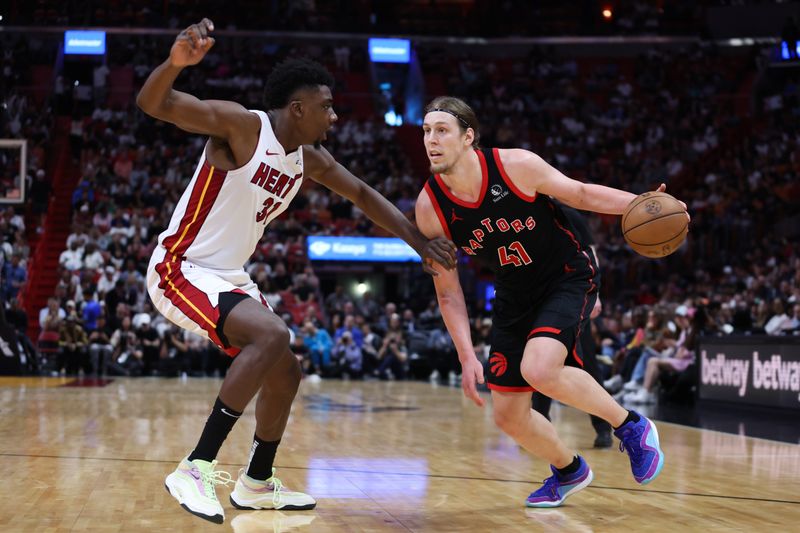 MIAMI, FLORIDA - APRIL 14: Kelly Olynyk #41 of the Toronto Raptors drives against Thomas Bryant #31 of the Miami Heat during the third quarter of the game at Kaseya Center on April 14, 2024 in Miami, Florida. NOTE TO USER: User expressly acknowledges and agrees that, by downloading and or using this photograph, User is consenting to the terms and conditions of the Getty Images License Agreement. (Photo by Megan Briggs/Getty Images)