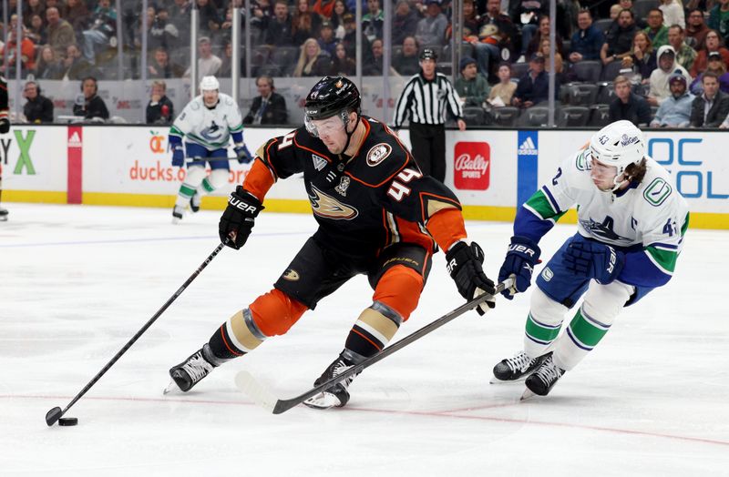 Mar 3, 2024; Anaheim, California, USA; Anaheim Ducks left wing Ross Johnston (44) skates against Vancouver Canucks defenseman Quinn Hughes (43) during the second period at Honda Center. Mandatory Credit: Jason Parkhurst-USA TODAY Sports