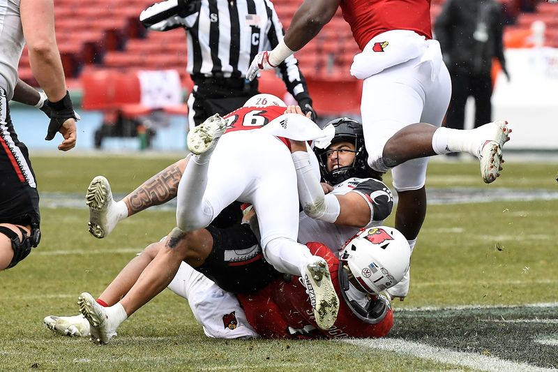 Dec 17, 2022; Boston, MA, USA; Cincinnati Bearcats quarterback Evan Prater (3) gets sacked by Louisville Cardinals linebacker Momo Sanogo (1) and safety M.J. Griffin (26) during the first half at Fenway Park. Mandatory Credit: Eric Canha-USA TODAY Sports