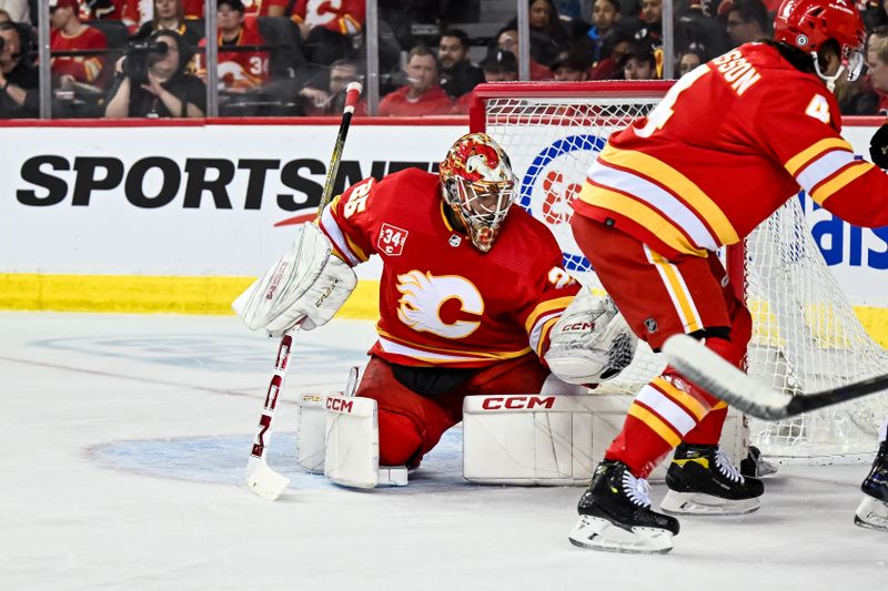 Mar 2, 2024; Calgary, Alberta, CAN; Calgary Flames goaltender Jacob Markstrom (25) makes a glove save against the Pittsburgh Penguins during the second period at Scotiabank Saddledome. Mandatory Credit: Brett Holmes-USA TODAY Sports