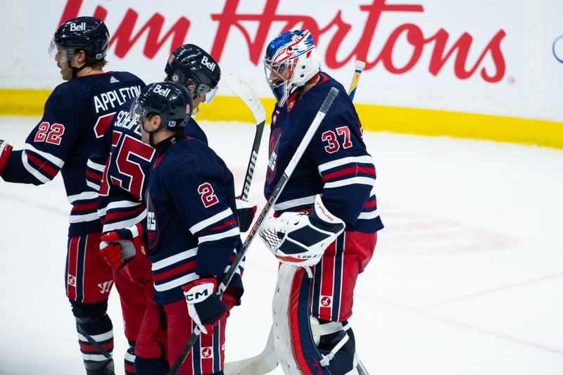 Feb 10, 2024; Winnipeg, Manitoba, CAN;  Winnipeg Jets goalie Connor Hellebuyck (37) is congratulated by his team mates on his win against the Pittsburgh Penguins at the end of the third period at Canada Life Centre. Mandatory Credit: Terrence Lee-USA TODAY Sports