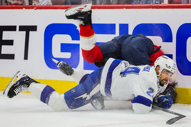 Apr 21, 2024; Sunrise, Florida, USA; Tampa Bay Lightning defenseman Matt Dumba (24) and Florida Panthers left wing Ryan Lomberg (94) collide agains the boards during the first period in game one of the first round of the 2024 Stanley Cup Playoffs at Amerant Bank Arena. Mandatory Credit: Sam Navarro-USA TODAY Sports