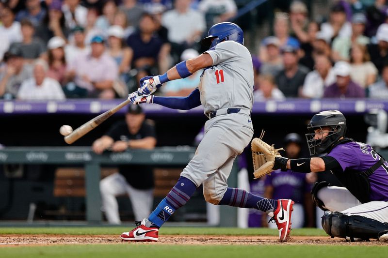 Jun 17, 2024; Denver, Colorado, USA; Los Angeles Dodgers shortstop Miguel Rojas (11) hits an RBI double in the seventh inning against the Colorado Rockies at Coors Field. Mandatory Credit: Isaiah J. Downing-USA TODAY Sports