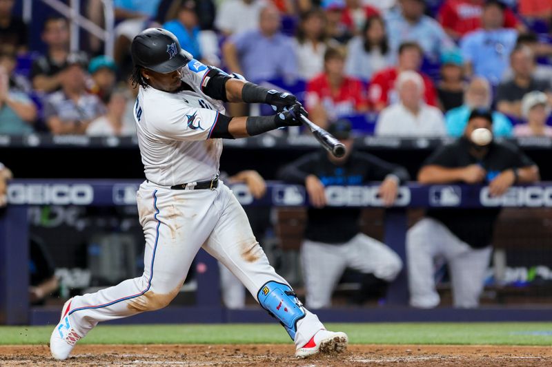 Jul 30, 2023; Miami, Florida, USA; Miami Marlins third baseman Jean Segura (9) hits a single against the Detroit Tigers during the fifth inning at loanDepot Park. Mandatory Credit: Sam Navarro-USA TODAY Sports