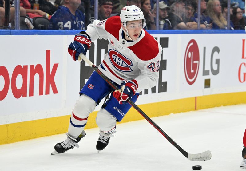 Sep 26, 2024; Toronto, Ontario, CAN;  Montreal Canadiens forward Lane Hutson (48) skates with the puck against the Toronto Maple Leafs in the first period at Scotiabank Arena. Mandatory Credit: Dan Hamilton-Imagn Images