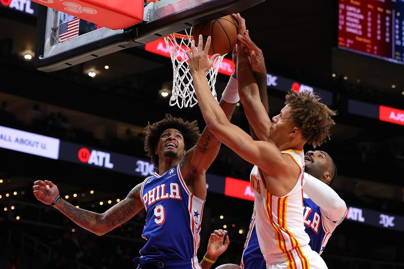 ATLANTA, GEORGIA - OCTOBER 14:  Dyson Daniels #5 of the Atlanta Hawks battles for a rebound against Kelly Oubre Jr. #9 and Andre Drummond #5 of the Philadelphia 76ers during the first quarter at State Farm Arena on October 14, 2024 in Atlanta, Georgia.  NOTE TO USER: User expressly acknowledges and agrees that, by downloading and/or using this photograph, user is consenting to the terms and conditions of the Getty Images License Agreement.  (Photo by Kevin C. Cox/Getty Images)