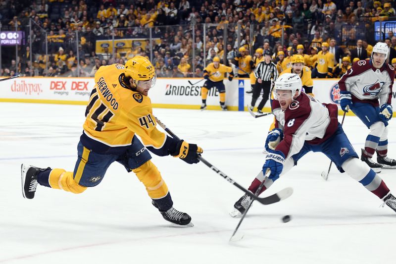 Mar 2, 2024; Nashville, Tennessee, USA; Nashville Predators left wing Kiefer Sherwood (44) shoots the puck against Colorado Avalanche defenseman Cale Makar (8) during the first period at Bridgestone Arena. Mandatory Credit: Christopher Hanewinckel-USA TODAY Sports