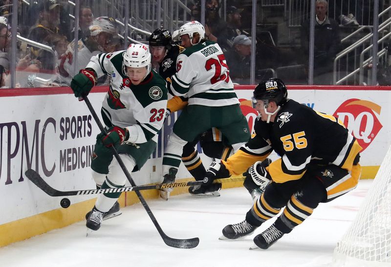 Oct 29, 2024; Pittsburgh, Pennsylvania, USA;  Minnesota Wild center Marco Rossi (23) and Pittsburgh Penguins center Noel Acciari (55) battle for the puck behind the net during the first period at PPG Paints Arena. Mandatory Credit: Charles LeClaire-Imagn Images