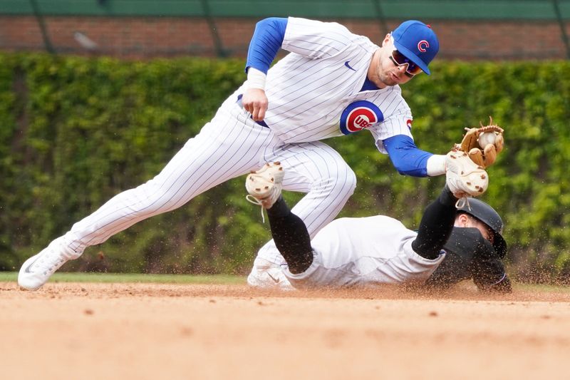 May 6, 2023; Chicago, Illinois, USA; Chicago Cubs second baseman Nico Hoerner (2) tags out Miami Marlins shortstop Jon Berti (5) at second base on a steal attempt of second base during the fifth inning at Wrigley Field. Mandatory Credit: David Banks-USA TODAY Sports