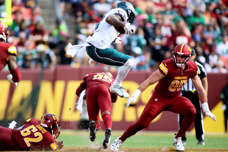 Philadelphia Eagles running back D'Andre Swift (0) leaps over Washington Commanders safety Percy Butler (35)during an NFL football game, Sunday, October 29, 2023 in Landover, Maryland. (AP Photo/Daniel Kucin Jr.)