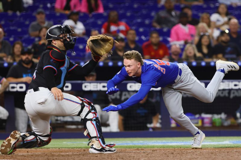 Aug 23, 2024; Miami, Florida, USA; Chicago Cubs center fielder Pete Crow-Armstrong (52) dives at home plate and scores against Miami Marlins catcher Nick Fortes (4) after hitting an inside-the-park home run during the third inning at loanDepot Park. Mandatory Credit: Sam Navarro-USA TODAY Sports