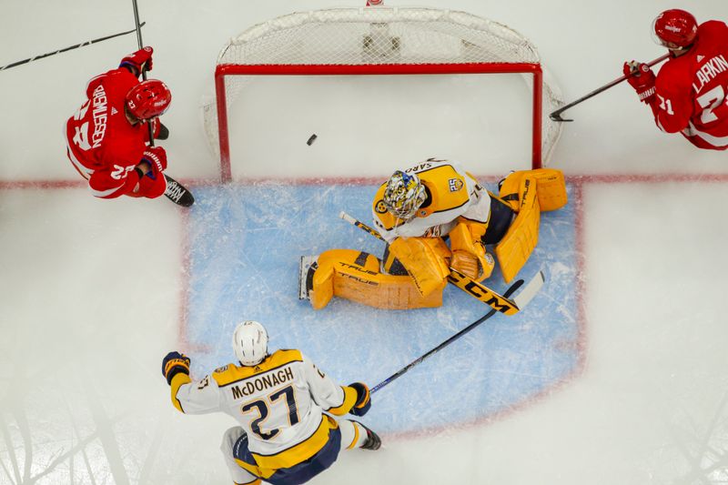 Dec 29, 2023; Detroit, Michigan, USA; The pucks slips past Nashville Predators goaltender Juuse Saros (74) during the game between the Detroit Red Wings and the Nashville Predators at Little Caesars Arena. Mandatory Credit: Brian Bradshaw Sevald-USA TODAY Sports