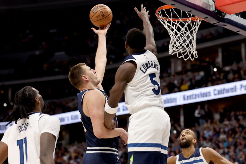 DENVER, COLORADO - APRIL 10: Nikola Jokic #15 of the Denver Nuggets goes to the basket against Anthony Edwards #5 of the Minnesota Timberwolves during the first quarter at Ball Arena on April 10, 2024 in Denver, Colorado. NOTE TO USER: User expressly acknowledges and agrees that, by downloading and or using this photograph, User is consenting to the terms and conditions of the Getty Images License Agreement.  (Photo by Matthew Stockman/Getty Images)