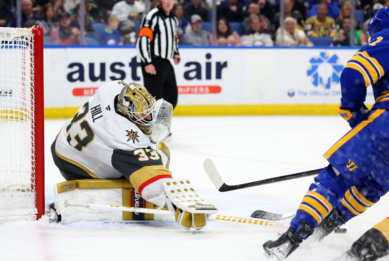 Mar 15, 2025; Buffalo, New York, USA;  Vegas Golden Knights goaltender Adin Hill (33) reaches for the puck during the second period against the Buffalo Sabres at KeyBank Center. Mandatory Credit: Timothy T. Ludwig-Imagn Images