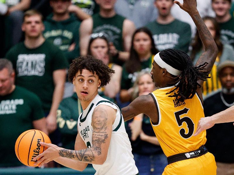 Feb 15, 2025; Fort Collins, Colorado, USA; Colorado State Rams guard Kyan Evans (0) controls the ball as Wyoming Cowboys guard Obi Agbim (5) guards in the first half at Moby Arena. Mandatory Credit: Isaiah J. Downing-Imagn Images
