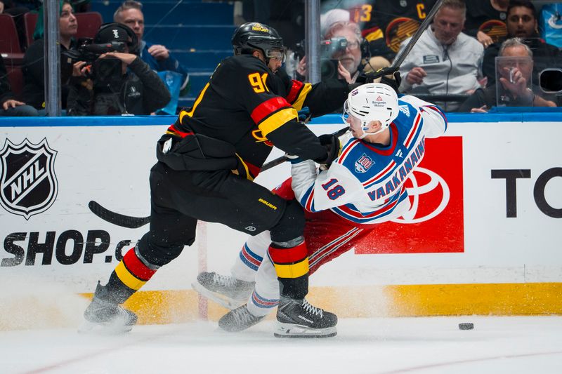 Oct 28, 2025; Vancouver, British Columbia, CAN; Vancouver Canucks forward Evander Kane (91) checks New York Rangers defenseman Urho Vaakanainen (18) in the second period at Rogers Arena. Mandatory Credit: Bob Frid-Imagn Images