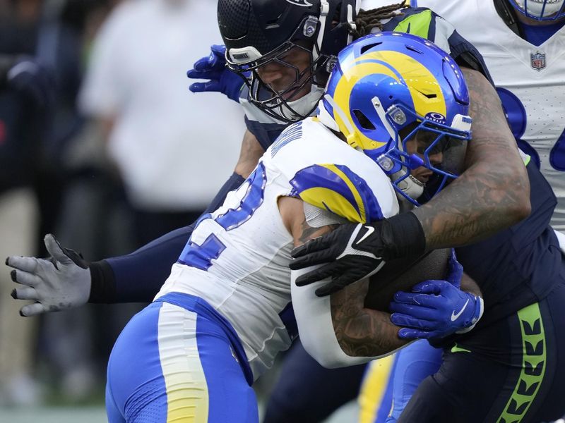 Seattle Seahawks defensive tackle Roy Robertson-Harris, top, tackles Los Angeles Rams running back Blake Corum during the first half of an NFL football game in Seattle, Sunday, Nov. 3, 2024. (AP Photo/Stephen Brashear)