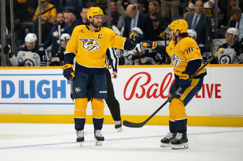 Nov 23, 2024; Nashville, Tennessee, USA;  Nashville Predators center Jonathan Marchessault (81) celebrates the goal of defenseman Roman Josi (59) against the Winnipeg Jets during the first period at Bridgestone Arena. Mandatory Credit: Steve Roberts-Imagn Images