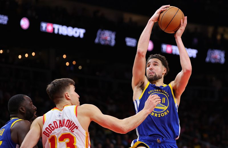 ATLANTA, GEORGIA - FEBRUARY 03:  Klay Thompson #11 of the Golden State Warriors drives against Bogdan Bogdanovic #13 of the Atlanta Hawks during the fourth quarter at State Farm Arena on February 03, 2024 in Atlanta, Georgia.  NOTE TO USER: User expressly acknowledges and agrees that, by downloading and/or using this photograph, user is consenting to the terms and conditions of the Getty Images License Agreement.  (Photo by Kevin C. Cox/Getty Images)