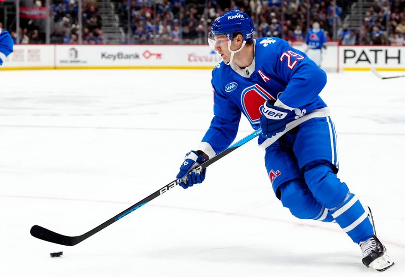 Nov 29, 2025; Denver, Colorado, USA; Colorado Avalanche center Nathan MacKinnon (29) controls the puck in the second period against the Montreal Canadiens at Ball Arena. Mandatory Credit: Ron Chenoy-Imagn Images