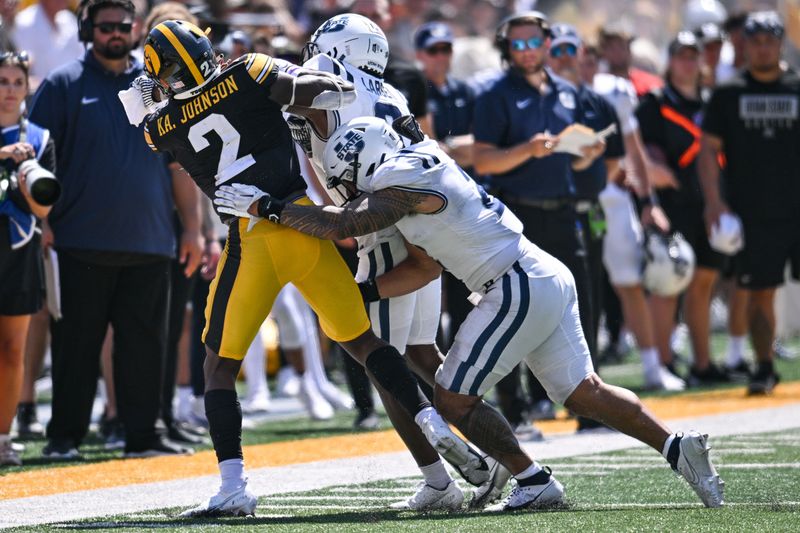 Sep 2, 2023; Iowa City, Iowa, USA; Iowa Hawkeyes running back Kaleb Johnson (2) is tackled by Utah State Aggies safety Ike Larsen (rear) and linebacker MJ Tafisi Jr. (2) during the third quarter at Kinnick Stadium. Mandatory Credit: Jeffrey Becker-USA TODAY Sports