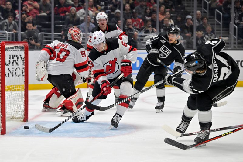 Mar 3, 2024; Los Angeles, California, USA; Los Angeles Kings center Phillip Danault (24) shoots under the stick of New Jersey Devils defenseman John Marino (6) for a goal in the second period at Crypto.com Arena. Mandatory Credit: Jayne Kamin-Oncea-USA TODAY Sports