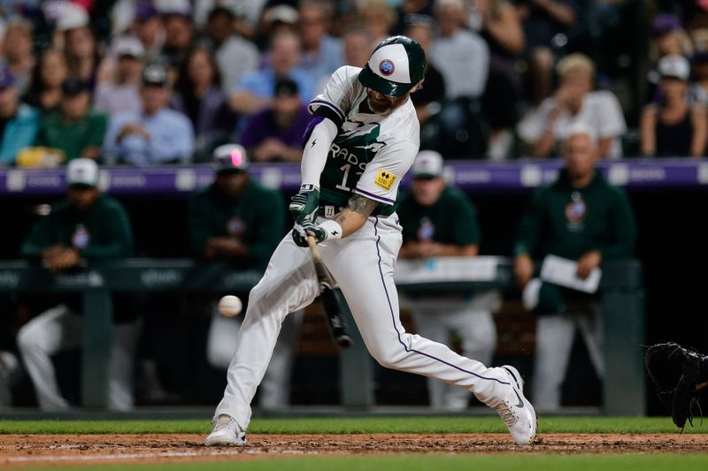 Aug 10, 2024; Denver, Colorado, USA; Colorado Rockies outfielder Jake Cave (11) hits a single in the seventh inning against the Atlanta Braves at Coors Field. Mandatory Credit: Isaiah J. Downing-USA TODAY Sports