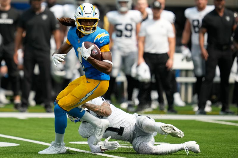 Los Angeles Chargers wide receiver Quentin Johnston, left, runs against Las Vegas Raiders safety Marcus Epps during the first half of an NFL football game, Sunday, Sept. 8, 2024, in Inglewood, Calif. (AP Photo/Ashley Landis)