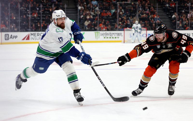 Mar 3, 2024; Anaheim, California, USA; Vancouver Canucks defenseman Filip Hronek (17) shoots against Anaheim Ducks left wing Max Jones (49) during the first period at Honda Center. Mandatory Credit: Jason Parkhurst-USA TODAY Sports