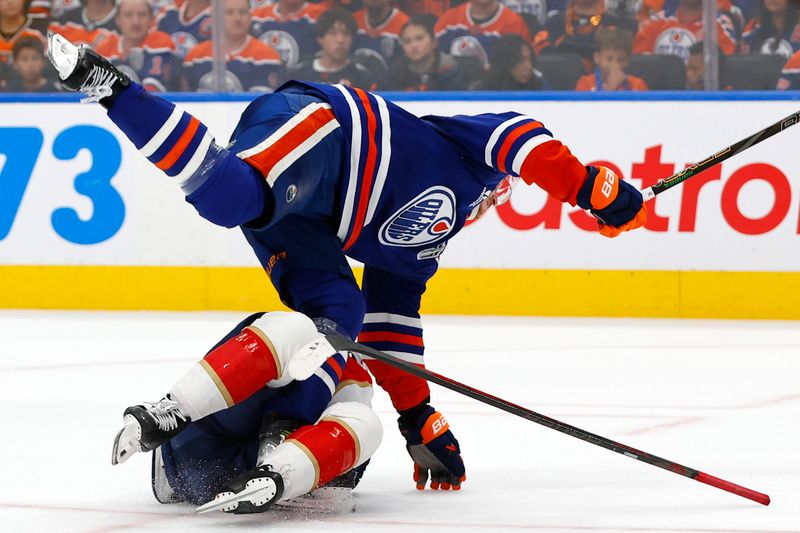 Jun 6, 2025; Edmonton, Alberta, CAN; Edmonton Oilers center Trent Frederic (21) checks Florida Panthers center Evan Rodrigues (17) during the first period in game two of the 2025 Stanley Cup Final at Rogers Place. Mandatory Credit: Perry Nelson-Imagn Images
