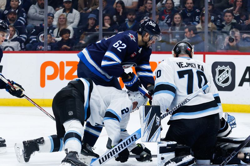 Nov 5, 2024; Winnipeg, Manitoba, CAN;  Winnipeg Jets forward Nino Niederreiter (62) jostles for position with Utah Hockey Club defenseman Olli Maatta (2) during the second period at Canada Life Centre. Mandatory Credit: Terrence Lee-Imagn Images