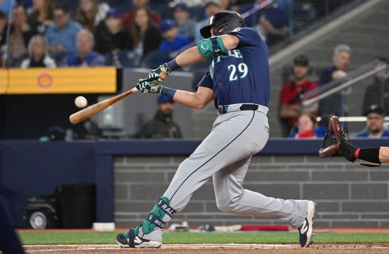 Apr 20, 2025; Toronto, Ontario, CAN;  Seattle Mariners catcher designated hitter Cal Raleigh (29) hits a two run home run against the Toronto Blue Jays in the first inning at Rogers Centre. Mandatory Credit: Dan Hamilton-Imagn Images