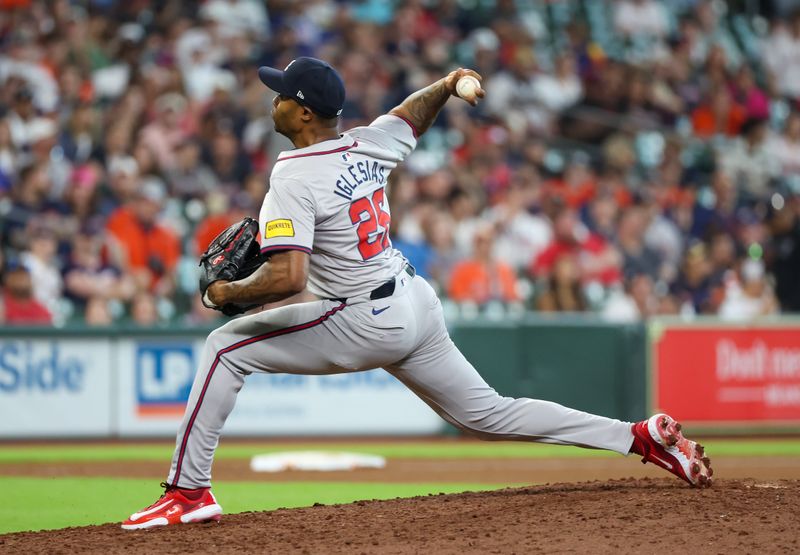 Apr 17, 2024; Houston, Texas, USA; Atlanta Braves pitcher Raisel Iglesias (26) pitches against the Houston Astros in the tenth inning at Minute Maid Park. Mandatory Credit: Thomas Shea-USA TODAY Sports